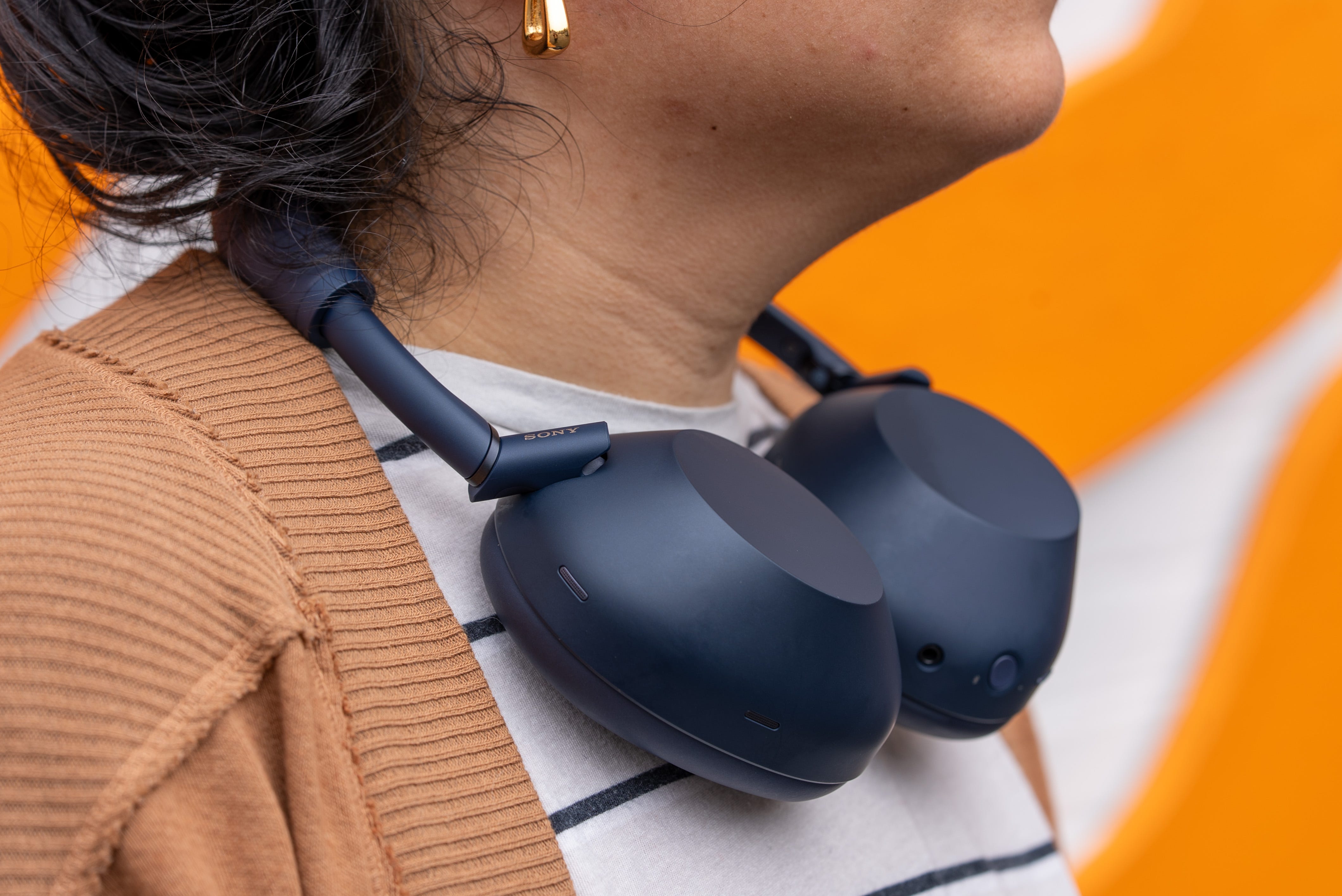 Person watching movie with Sony WH-1000XM6 headphones at home